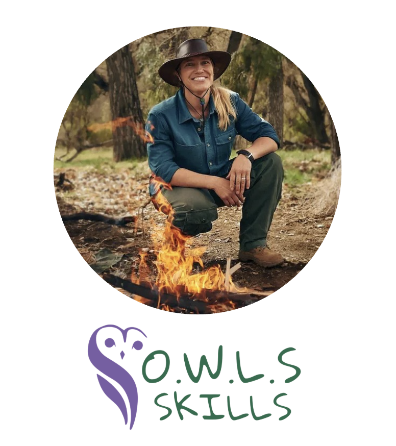 Jessie Krebs, a blonde white woman, is wearing a brown cowboy hat, jeans button up shirt, and green pants as she kneels behind a campfire.